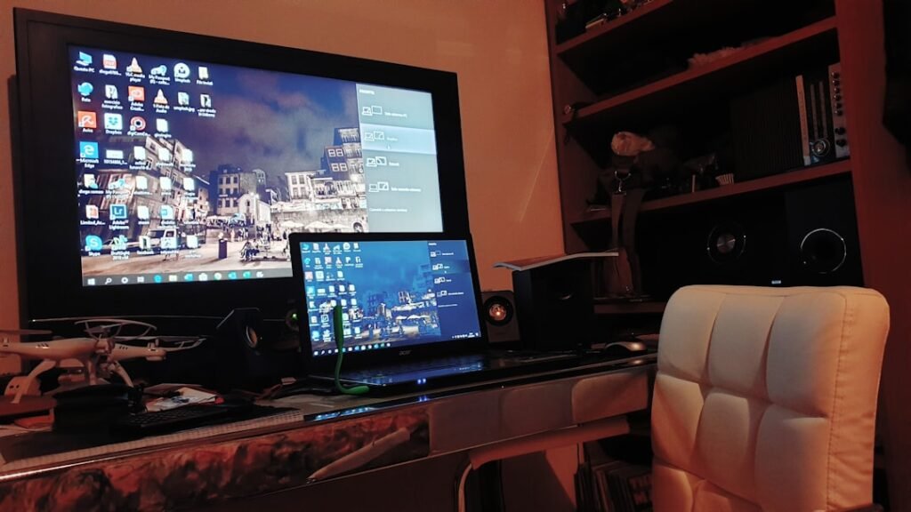 Modern gaming setup with laptop and monitor displaying browser games interface