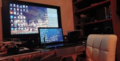 Modern gaming setup with laptop and monitor displaying browser games interface