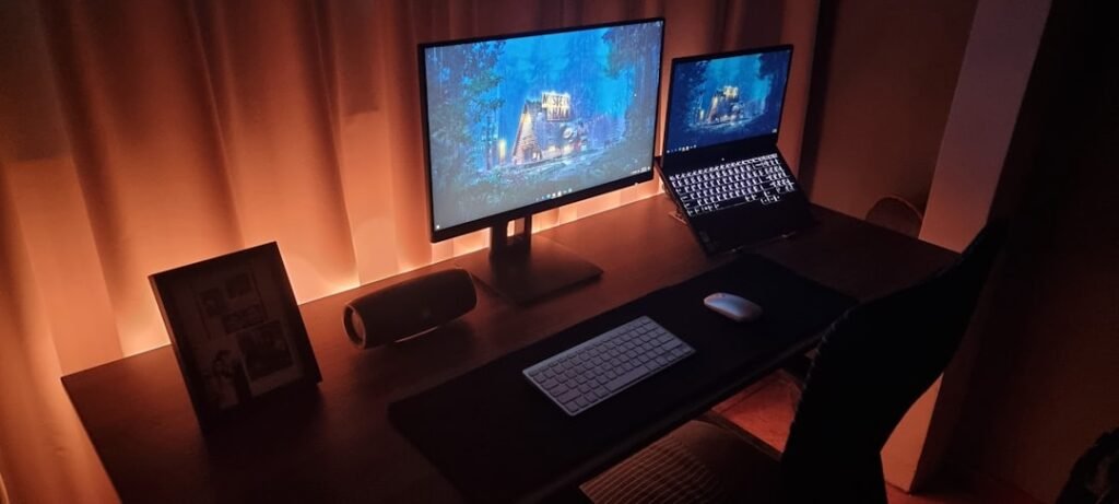 Modern dual-screen gaming setup for cross-platform survival games. Photo by Unsplash contributor.