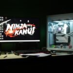 Gaming computer setup with colorful monitor displaying video game interface